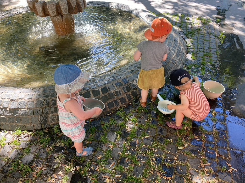 Kind spielt am Brunnen