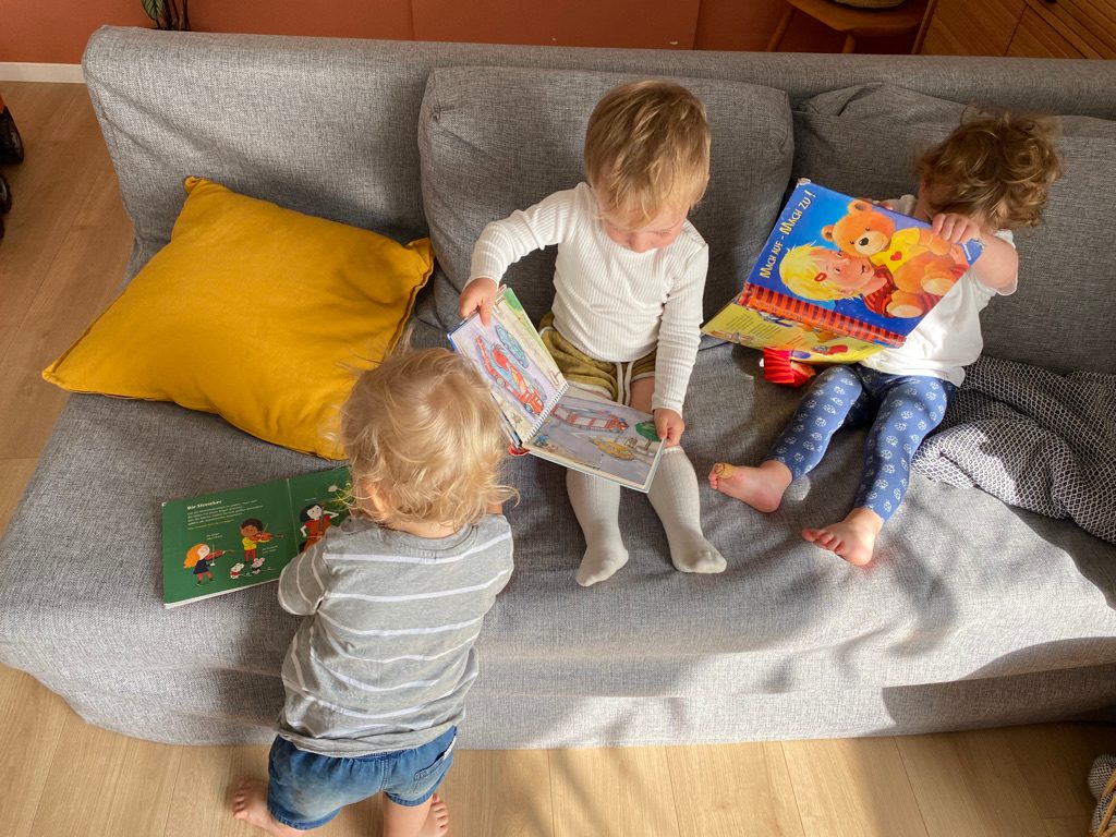 Kind mit Buch auf dem Sofa